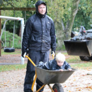 Mand der kører med et barn i trillebør