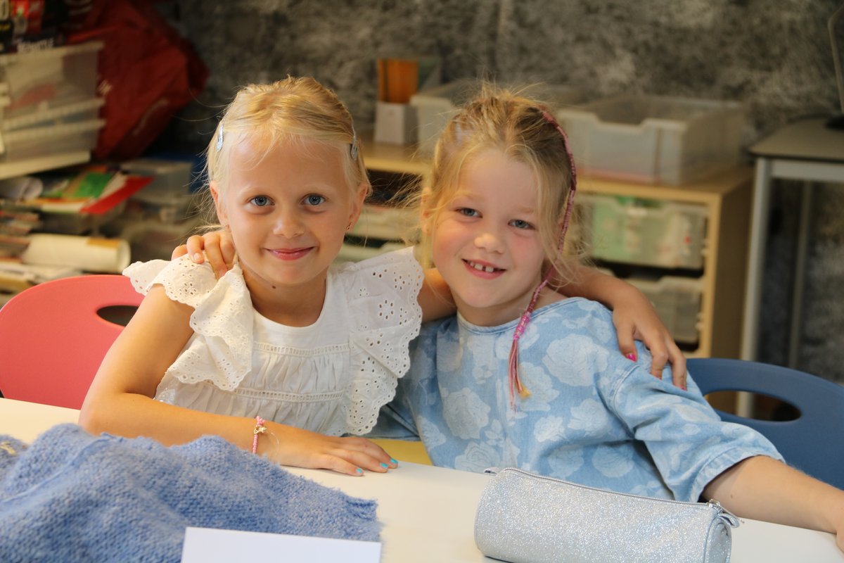 Første skoledag To piger med rygsæk på første skoledag foran skolen.