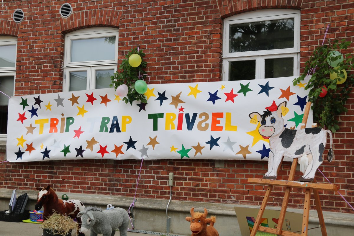 Trip Trap Trivsel Håndlavet banner med teksten Trip Trap Trivsel og farverige stjerner.